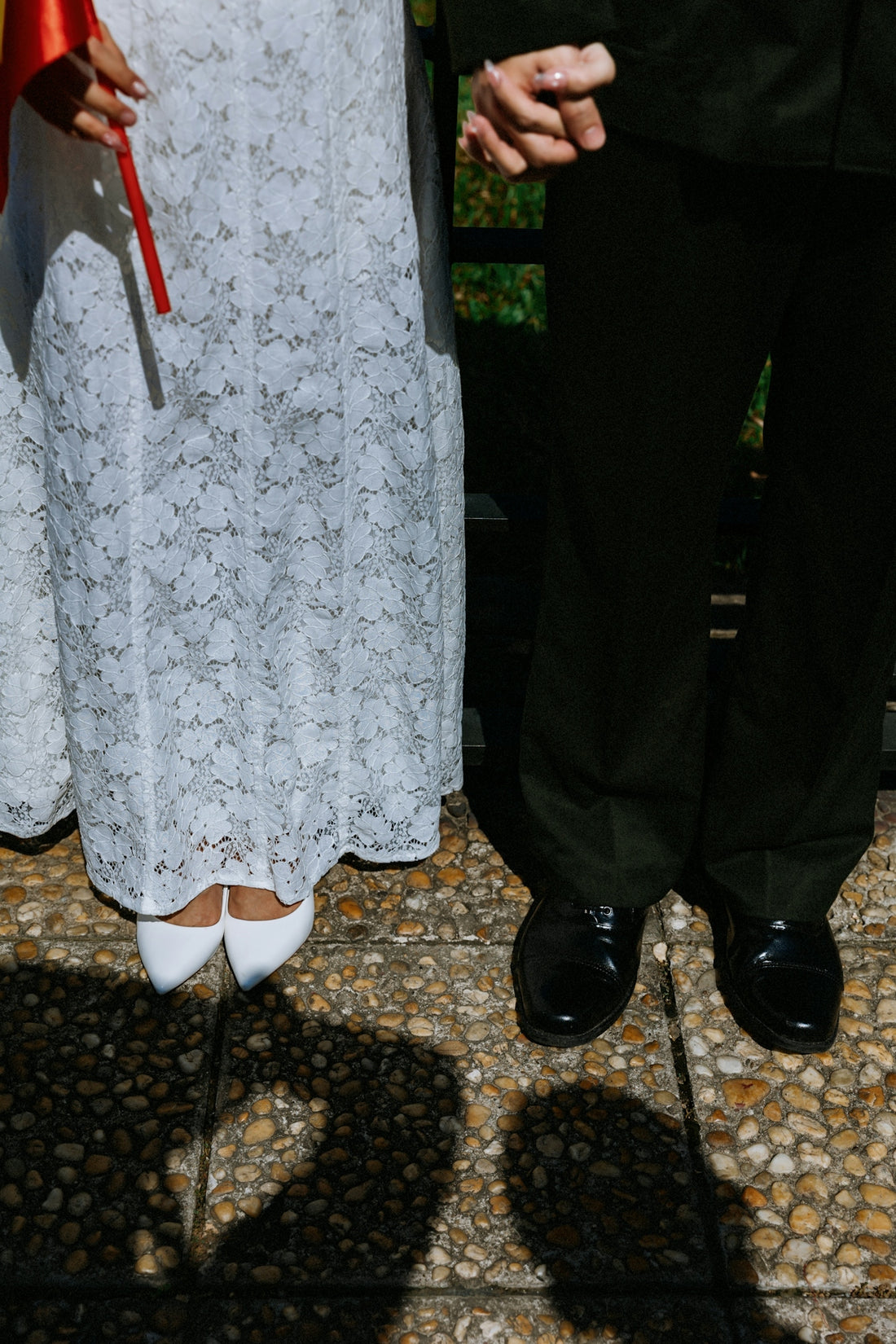 Couple holding hands, dressed for a formal occasion.