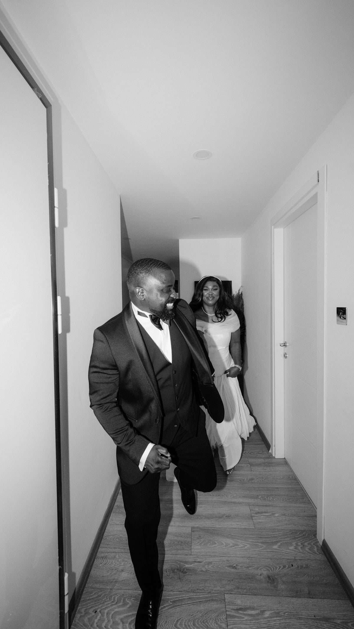 Couple in formal wear running down a hallway