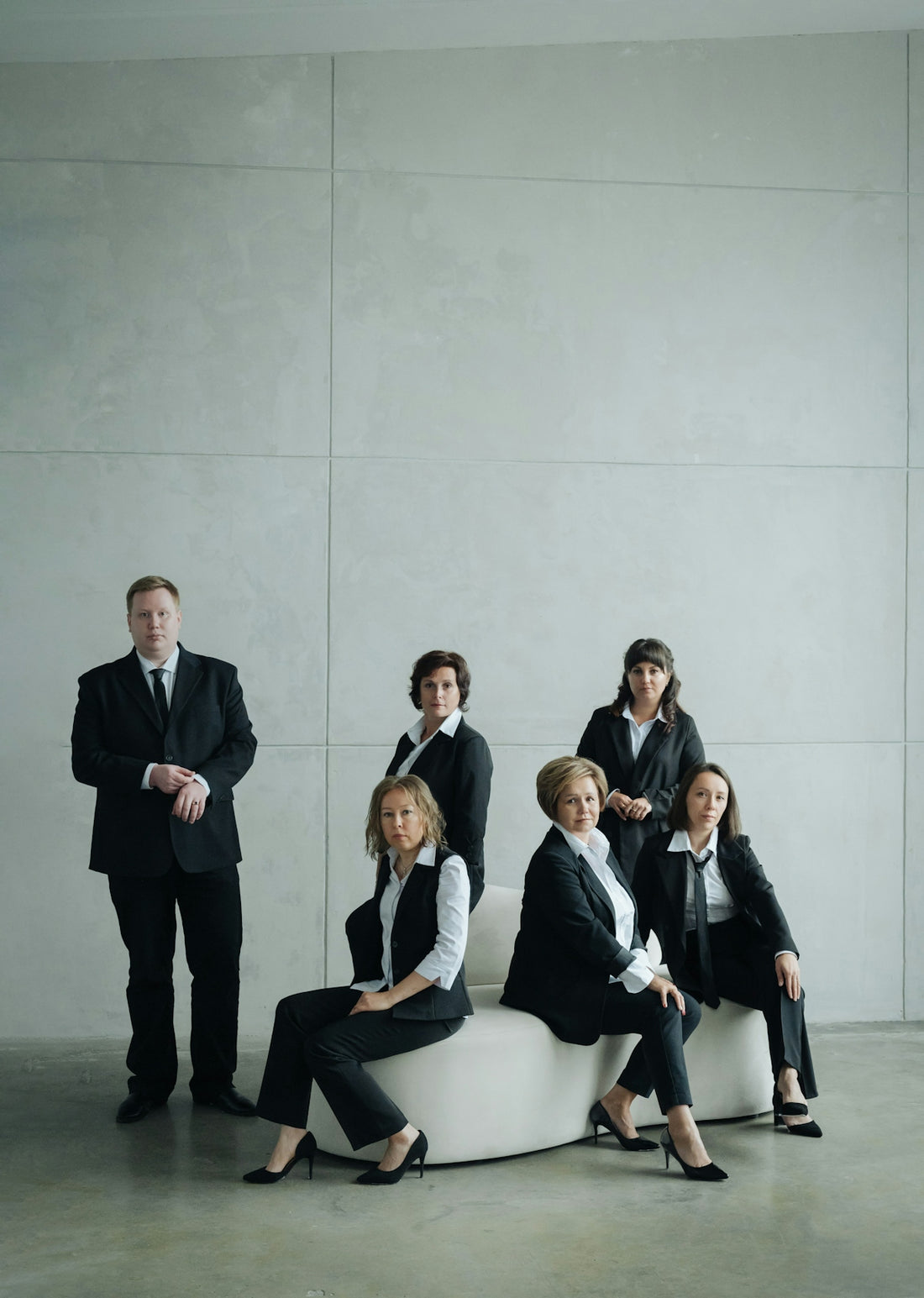 Group of business people in formal attire posing indoors
