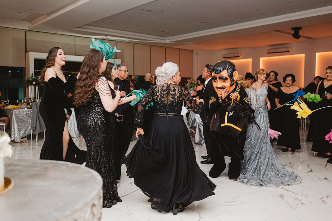 People in formal attire dancing at a masquerade party.