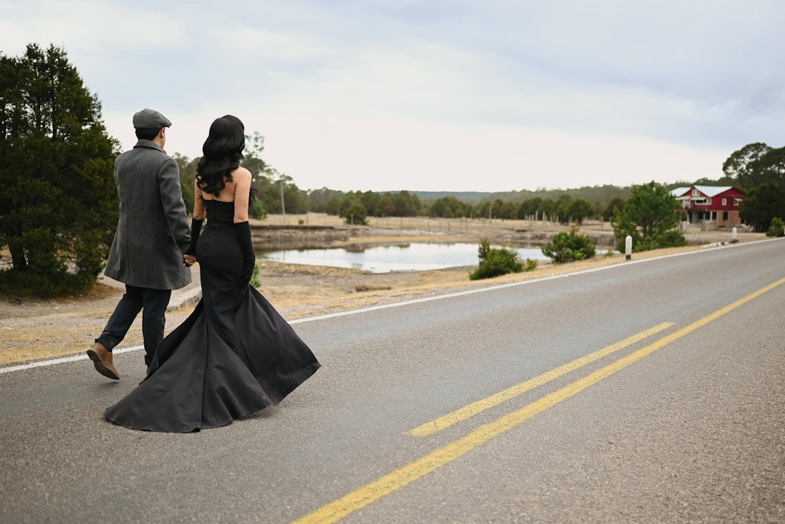 Couple in formal wear walking on a rural road